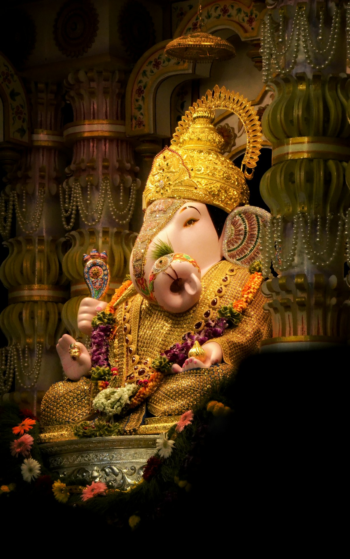 Golden Ganesha idol with crown and flower garlands in temple — Ganesh Chaturthi 2026